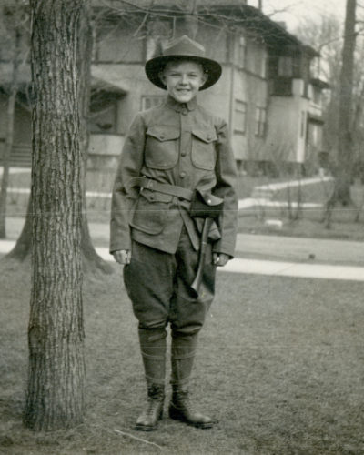 The first Scout uniform included brown jackets with a high collar. These jackets were worn with breeches, canvas leggings or long socks to protect the calves as well as the broad-brimmed campaign hats. The original uniform was shortly revised, replacing the jacket with a light shirt and its high collar with neckerchiefs; shorts were added as a new option.